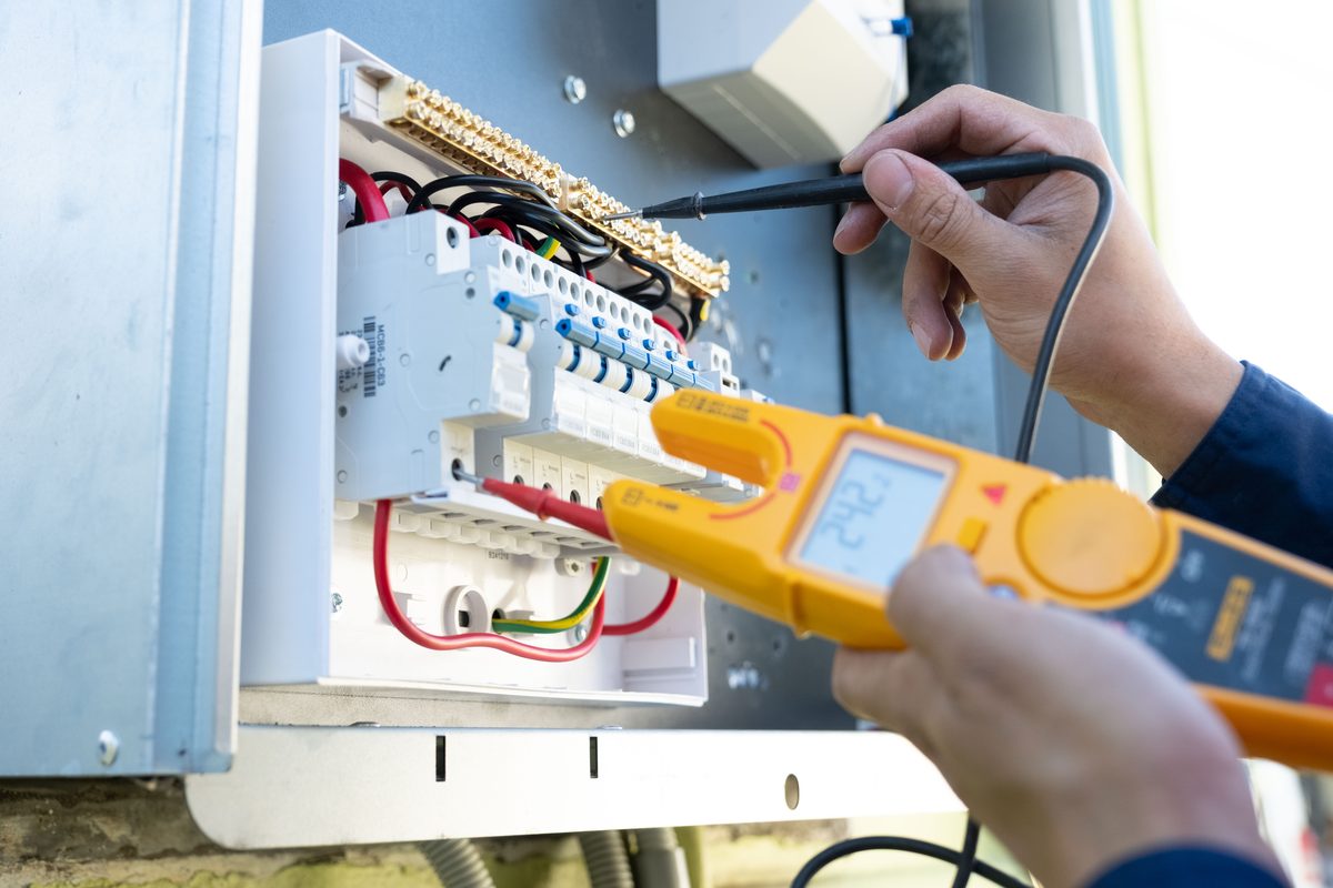 Electrical Genius electrician testing a switchboard with a multimeter